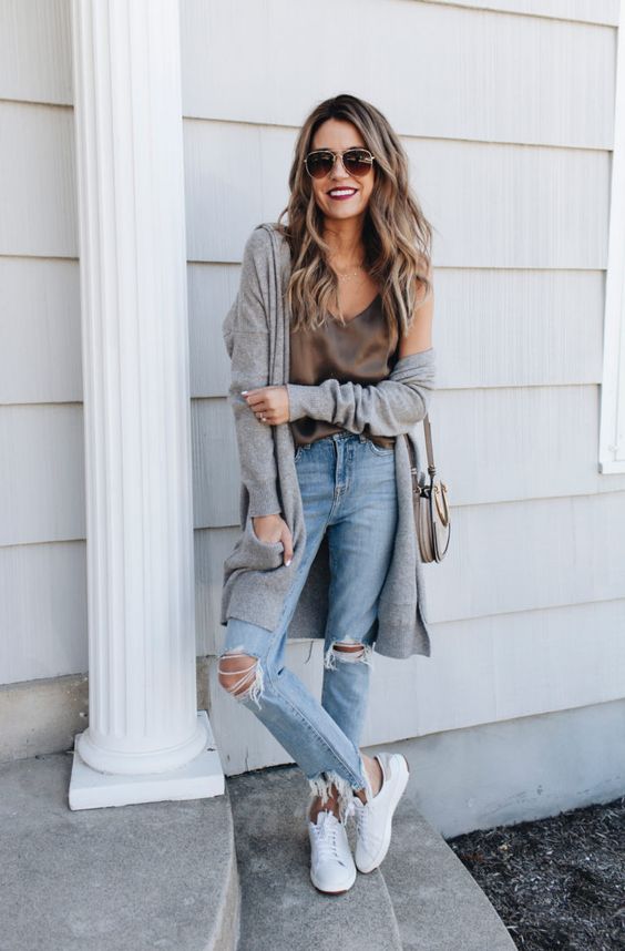 blue ripped jeans, a taupe silk strap top, a grey cardigan, white sneakers and a grey bag