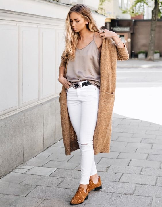 white jeans, a grey silk spaghetti strap top, amber booties and a tan long cardigan