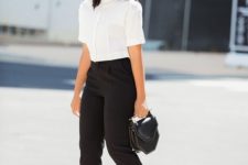 04 a white button down with short sleeves, black pants, white heels and a small black bag is a modern take on classics