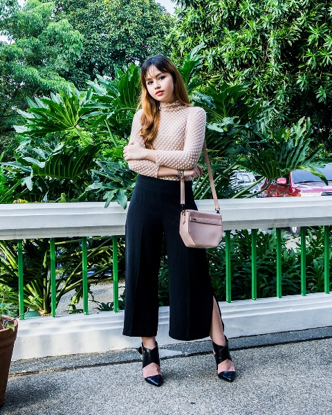 With beige blouse, leather bag and black high heels
