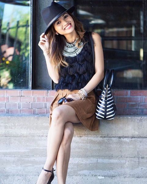 With black hat, striped bag, necklace, brown skirt and black shoes