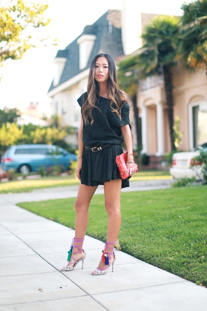 With black mini dress, belt and red clutch