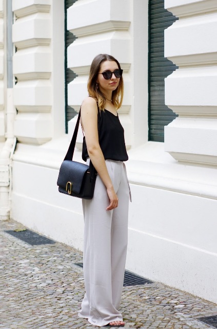With black shirt, black leather bag and sandals