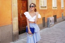 With light blue ruffled skirt, cobalt blue clutch and white sneakers