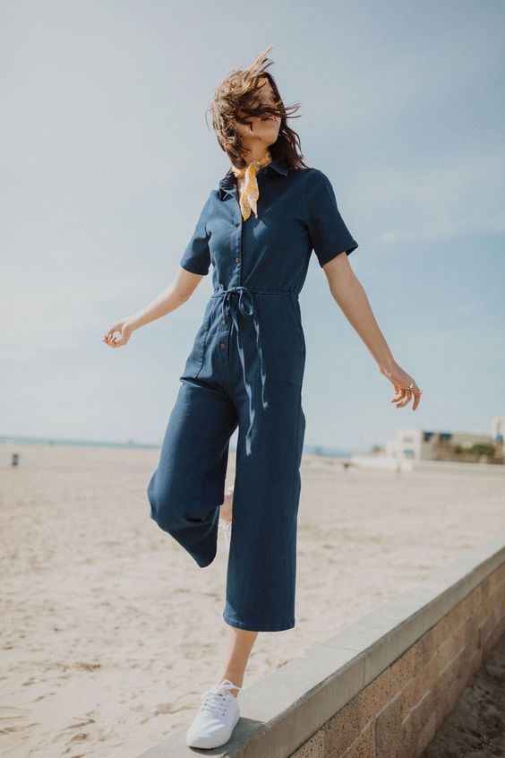 a navy boiler suit with cropped pants, short sleeves and a row of buttons plus white sneakers for summer