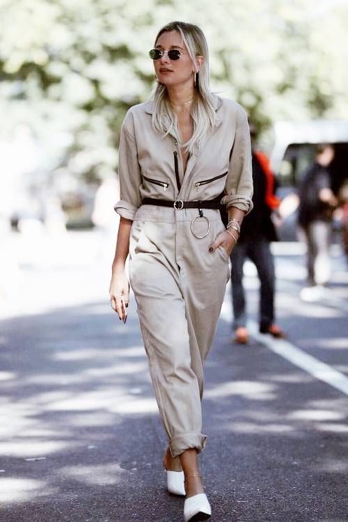 a neutral boiler suit with black touches and a black belt, white mules and sunglasses