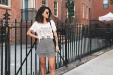 a white printed tee, a checked mini skirt with a catchy detail, black mules and a black bag