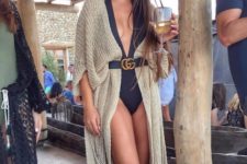 02 a black one piece swimsuit with a plunging neckline and a crochet coverup with a belt plus sunglasses