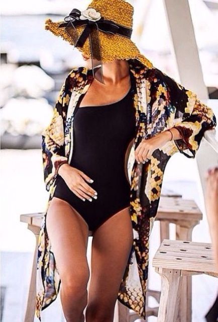 a black one piece swimsuit with a snake print beach kimono, the latter being one of the hottest trends