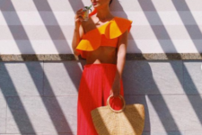 13 bright red culottes, a bright orange crop top with a ruffle, a straw bag and shiny mules