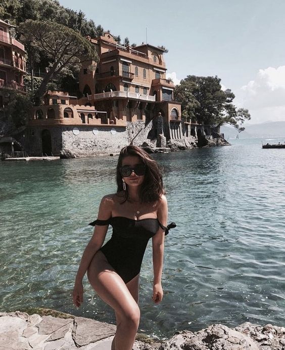 a black one piece swimsuit with off the shoulder straps with knots is a hot idea