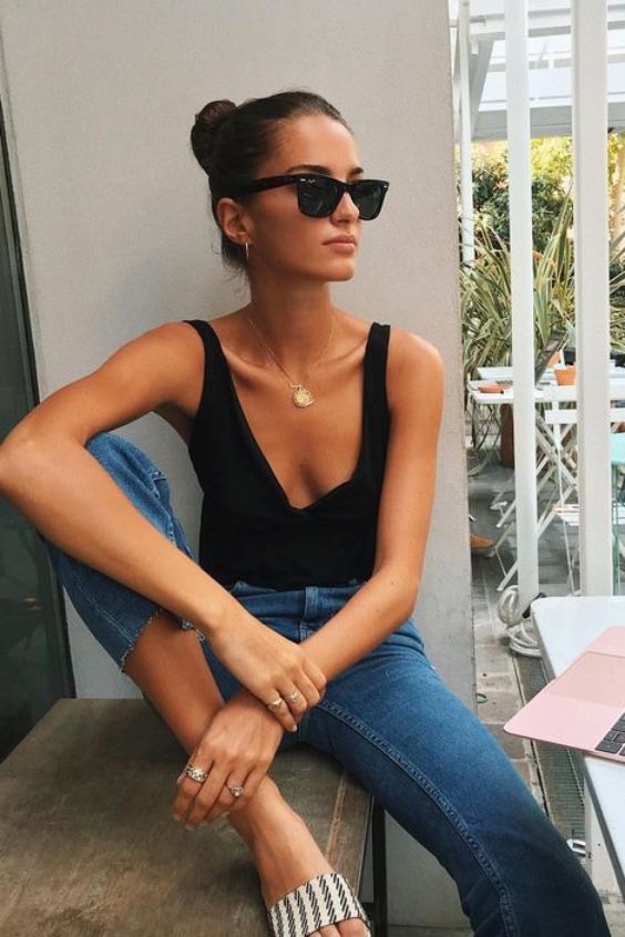 a simple sexy outfit with a black tee with straps, blue cropped jeans and printed slippers