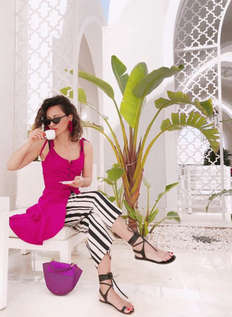 striped black and white culottes, a fuchsia over the knee dress, lace up sandals and a purple bag