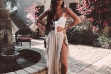 15 a white bikini with a tied top, a blush maxi skirt with a slit, a white hat
