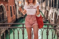 16 a white printed tee, striped red and white shorts, white slipper mules and a trendy bag