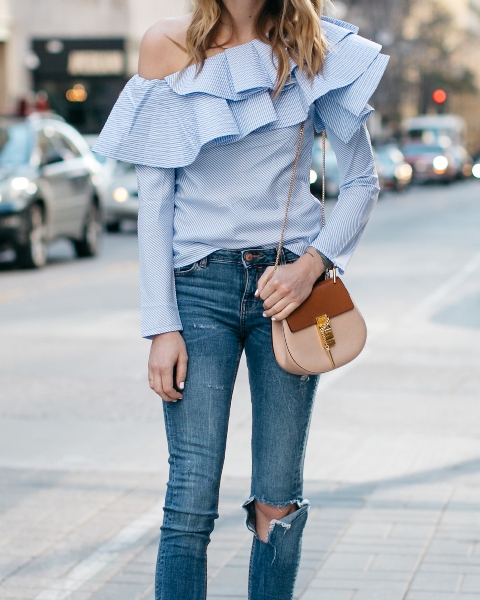 With distressed jeans and brown and beige bag