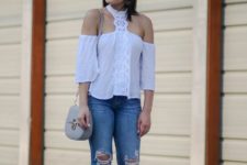 With distressed jeans, gray chain strap bag and sandals
