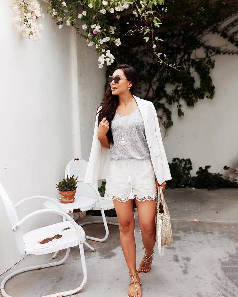 With gray top, white blazer, straw bag and flat sandals