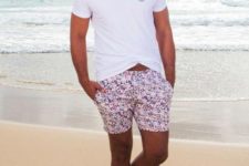 a white tee, bright floral swim trunks, flipflops and a straw hat for a comfy beach outfit