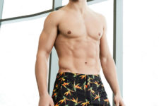 dark swim trunks with a bright tropical flower print is a cool idea that looks manly