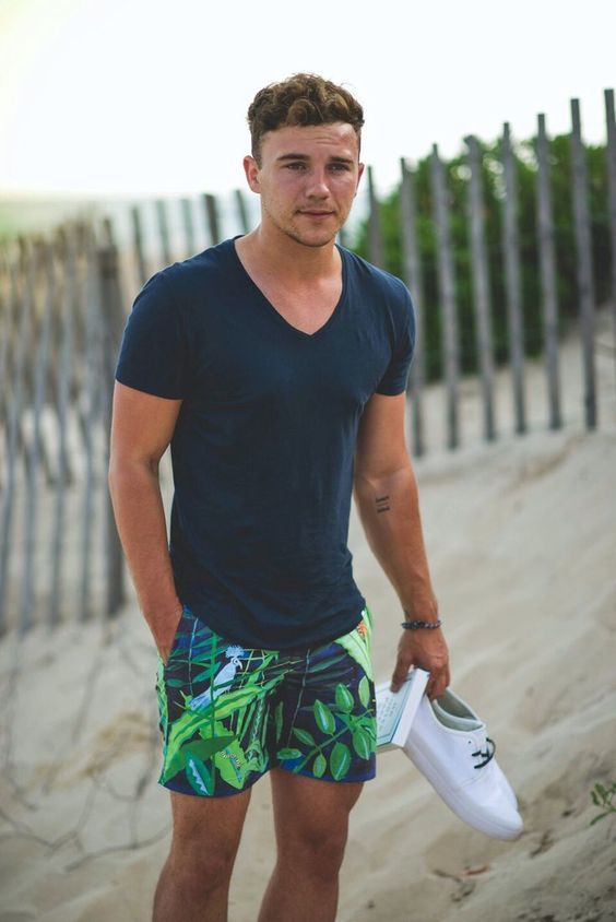 super colorful botanical print swim trunks paired with a navy shirt for a bright beach look