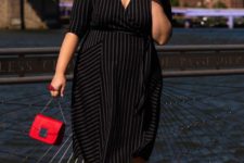 03 a black wrap midi dress with thin stripes, black heels and a small red bag for a bold look