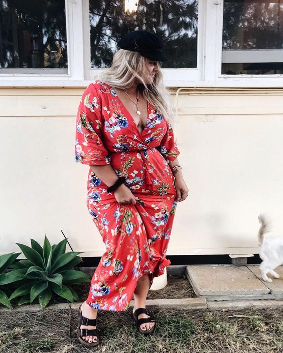 a red floral wrap maxi dress is finished off with blakc dad sandals and a cap