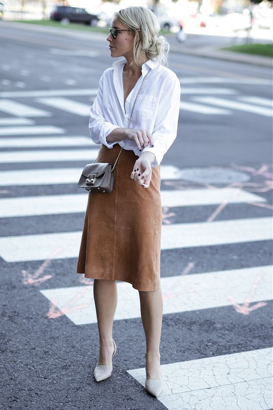 a white shirt, a camel suede skirt, creamy shoes and a small brown bag