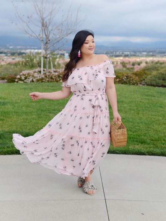 a super romantic pink off the shoulder maxi dress with a floral print, slippers and a wooden bag