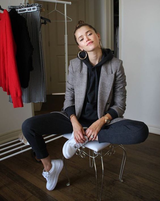 black sporty pants, a black hoodie, white sneakers, a grey blazer and statement earrings for a sport chic look