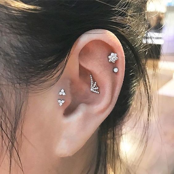 a little spiderweb stud in the upper conch, a double helix piercing and a double tragus one