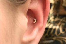 04 a tiny cute half moon conch piercing in the upper part of the ear cartilage looks very pretty and cute