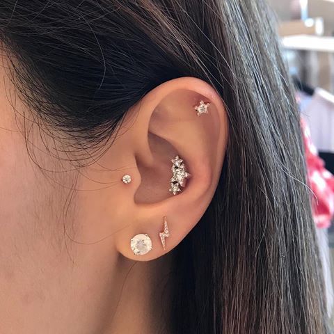 shiny star piecrings in the conch, daith and tragus piercing make this ear super shiny