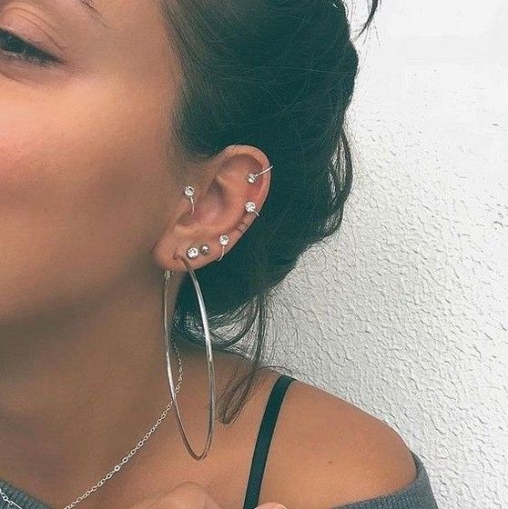  a boldly accessorized ear with rhinestone hoops and a giant hoop is a very chic idea
