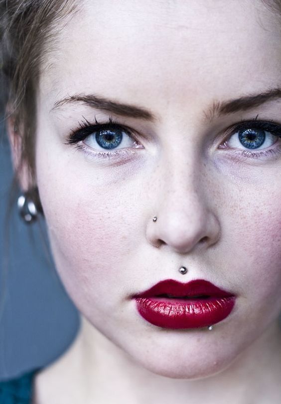 a stud piercing in the nose, over and under the lip for a chic statement
