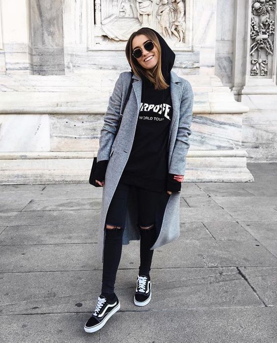 black ripped jeans, a black hoodie, black Vans sneakers and a grey coat for a cool look