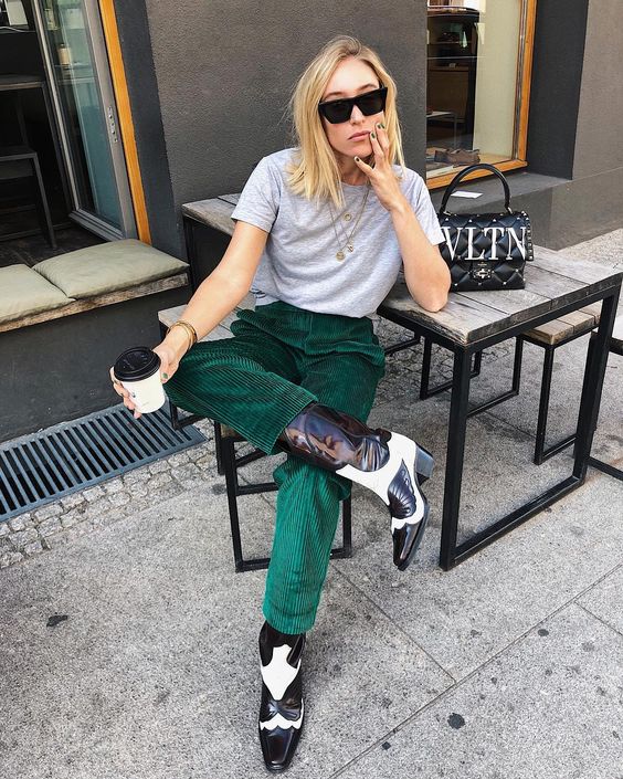 emerald velvet pants, a grey t-shirt, black and white cowboy boots that make a bold statement