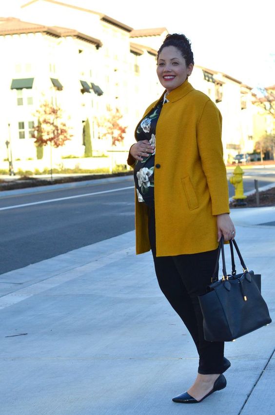 black jeans, a dark floral shirt, black flats, a bright mustard coat for a bold look this fall