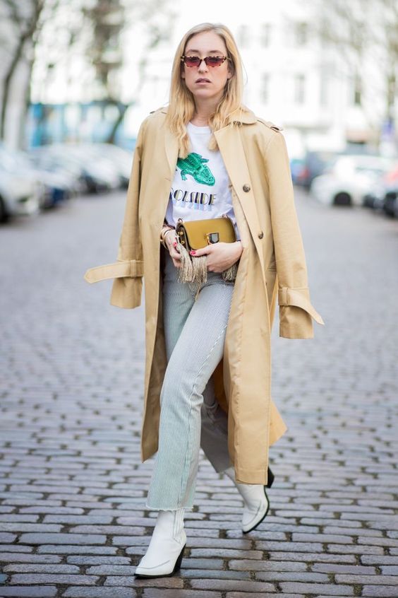 a printed tee, bleached jeans, white cowboy boots and a long camel trench for a touch of classics