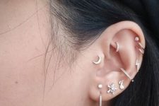 11 bold ear accessorizing with all kind sof piercings including tragus, with hoops and studs in the same style