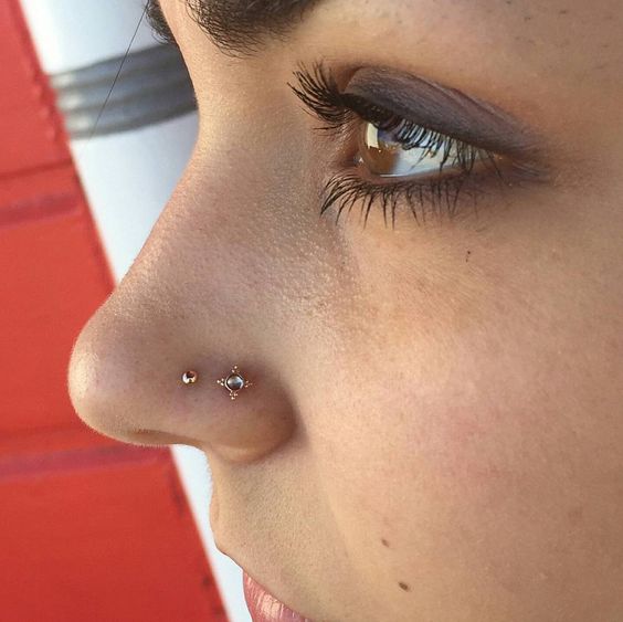 double gold nose piercing will accent your face a lot, choose bold studs for a brighter look
