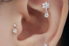 13 gorgeous ear accessorizing with daith, lap and double tragus piercing with shiny rhinestone floral studs