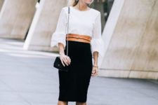 With white blouse, black knee-length skirt, chain strap bag and ankle boots