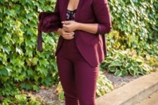 a burgundy pantsuit, a florla bodice, blakc shoes and a burgundy velvet bag can be easily transitioned to a party look
