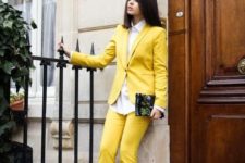 a lemon yellow pantsuit, a white shirt, black pointed toe heels and a floral clutch for a summer or spring feel