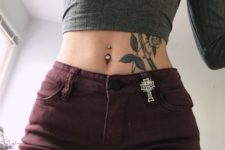 a shiny rhinestone belly button piercing and a matching shiny cross hung on the shorts to highlight the look