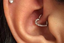 cute ear accessorizing with a lobe, flat and daith piercing, with shiny studs and a heart with rhinestones