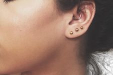 gold studs in the lobe and a single ring in the daith for a modern and bold look