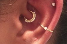 hoops and studs in the ear including a daith piercing with a rhinestone hoop for a shiny touch