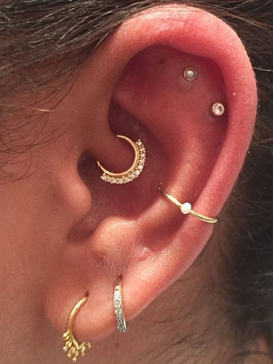 hoops and studs in the ear including a daith piercing with a rhinestone hoop for a shiny touch